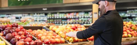 An Image of a man picking up Sobeys freshly produce fruits.