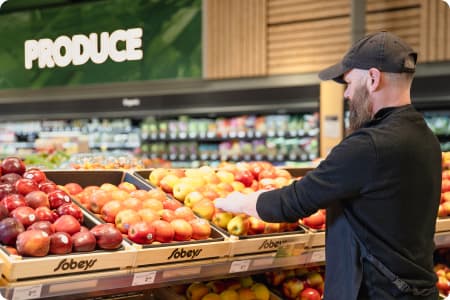 An Image of a man picking up Sobeys freshly produce fruits.